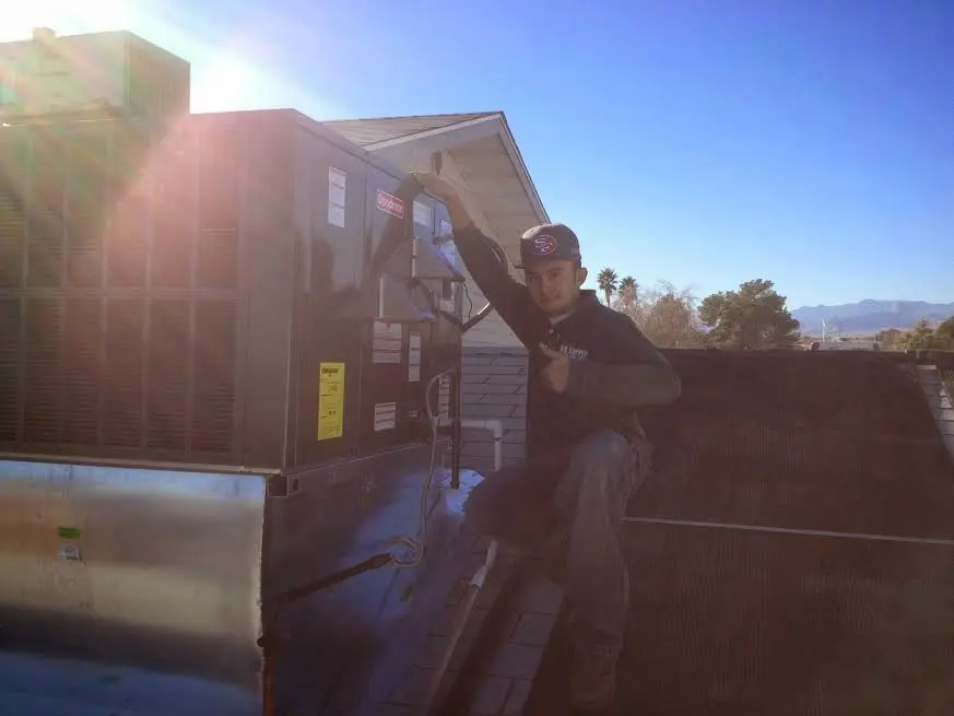 HVAC technician performing AC Tune-Up on a rooftop unit in Pukalani